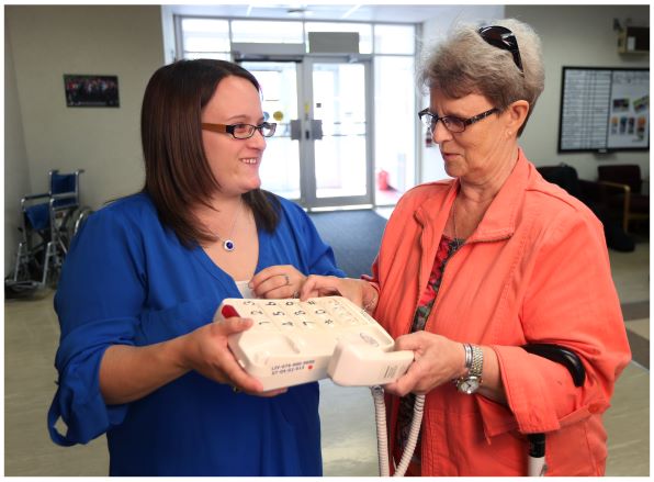 Woman shows another woman a large-button phone