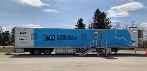 Une photo du camion-remorque bleu et blanc arborant le logo Eye Van.