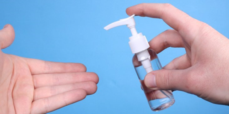 Hands applying hand sanitizer