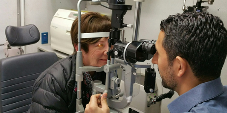 Eye doctor conducts eye exam with patient