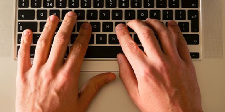 Hands typing on a laptop 