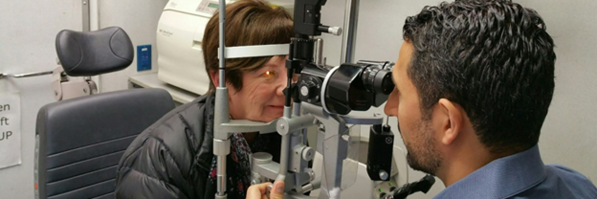 Eye doctor conducts eye exam with patient
