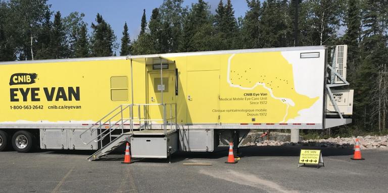 Picture of the Eye Van in a parking lot surrounded by trees
