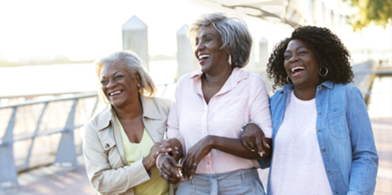 Three ladies walk arm in arm